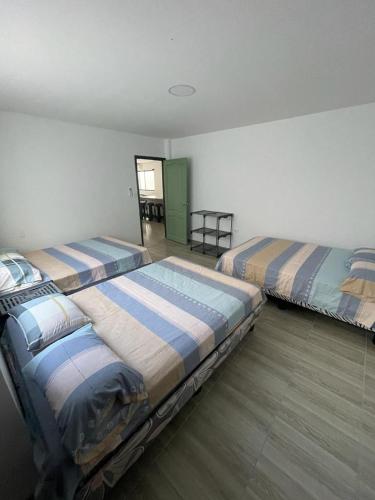 a room with two beds in a room at Casa Halley #6 con vista al mar in Playas