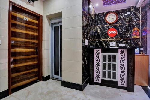 a lobby with a door and a clock on the wall at OYO Flagship Hotel Metro Height's near Nangloi Railway metro station in New Delhi