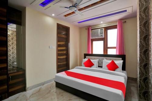 ニューデリーにあるOYO Flagship Hotel Metro Height's near Nangloi Railway metro stationのベッドルーム1室(大型ベッド1台、赤い枕付)