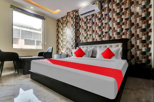 a bedroom with a large bed with red pillows at OYO Flagship Hotel Metro Height's near Nangloi Railway metro station in New Delhi