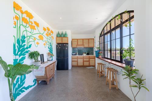 a kitchen with flowers painted on the wall at THE SWAN BINGIN - 360 Ocean & Uluwatu Hills View in Bingin Beach in Uluwatu
