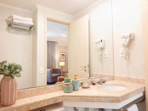 La salle de bains est pourvue d'un lavabo et d'un grand miroir. dans l'établissement EASY STAR - Flat Aconchegante ao lado da Av Paulista - AK01H, à São Paulo