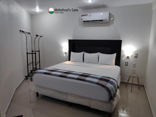 1 dormitorio con 1 cama con manta blanca y negra en Mahahual's Gate (Kalan Naay), en Mahahual