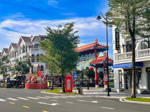 uma rua da cidade com edifícios e uma cabine telefónica vermelha em DNh Phu Quoc - Shanghai Town - Grand World em Duong Dong