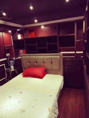 a bedroom with a bed with a red pillow on it at Grand Illusyin in Shah Alam