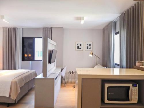 um quarto de hotel com uma cama e uma televisão em Easy Star - Flat Aconchegante C/Vaga na Bela Cintra - XA03G em São Paulo