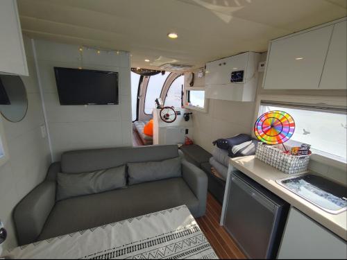 ein kleines Wohnzimmer mit einem Sofa und einem TV in der Unterkunft Tagoja Caravanboat Stay in Tongyeong