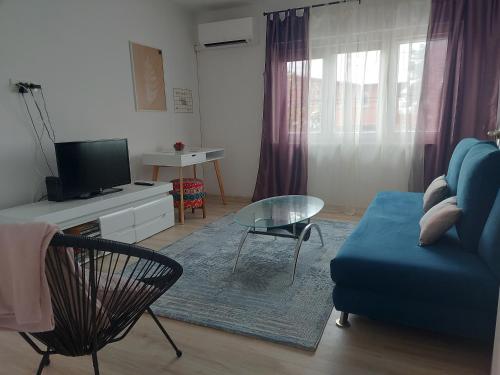 sala de estar con sofá azul y mesa de cristal en Apartment Panorama en Sarajevo