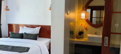 1 dormitorio con cama, espejo y lavamanos en Zifa Kuta Lombok, en Kuta Lombok