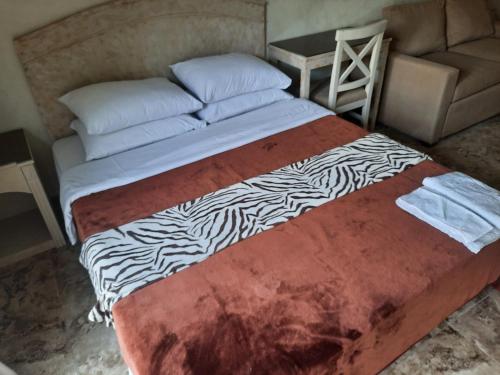 een groot bed in een kamer met een stoel en een bank bij Pool front, Fast Wi-Fi, Great location in Sharm El Sheikh