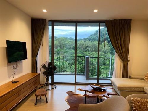 a living room with a couch and a large window at The Valley by Pook46 in Nakhon Ratchasima