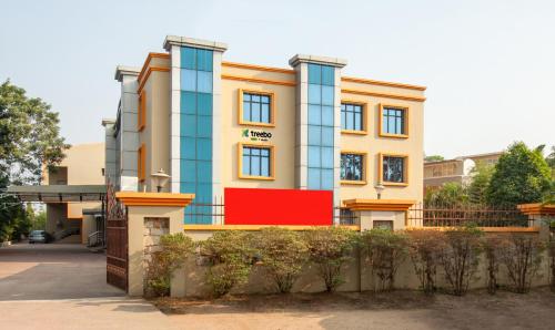 a building with a red sign in front of it at Treebo Trend Y Hotels Elite - Jagamara in Bhubaneshwar