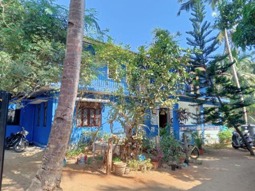 a blue house with trees in front of it at Seashell in Madgaon