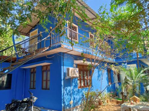 a blue house with a balcony at Seashell in Madgaon