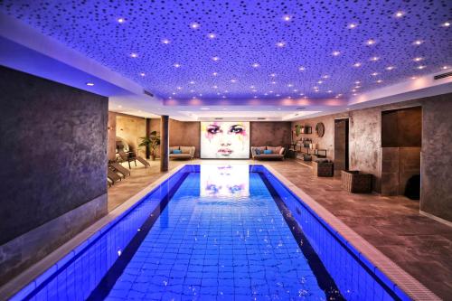 a swimming pool in a hotel with a painting of a woman at Die Seefelderin - Boutiquehotel St. Georg in Seefeld in Tirol