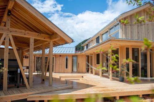 a wooden house with a large deck at 木を楽しむ一棟貸しの宿「ウッドヴィラ 心楽 -SHIGURA-」 in Tamba