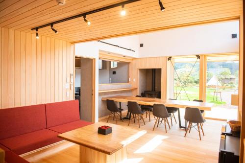a living room with a large wooden table and chairs at 木を楽しむ一棟貸しの宿「ウッドヴィラ 心楽 -SHIGURA-」 in Tamba