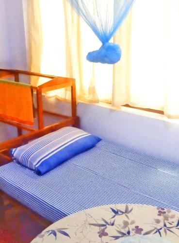 Bett in einem Zimmer mit Fenster in der Unterkunft Dambulla Eco Homestay. in Dambulla