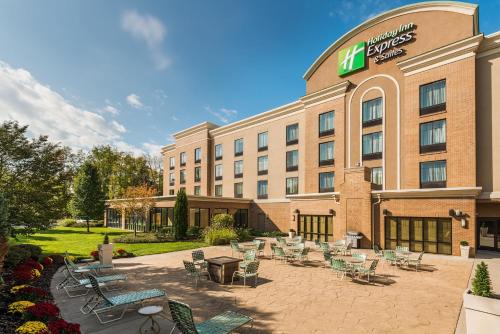a hotel with chairs and tables in a courtyard at Holiday Inn Express Hotel & Suites Rochester Webster, an IHG Hotel in Webster