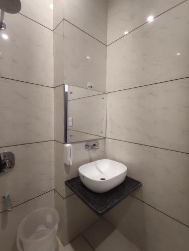 a bathroom with a white sink and a toilet at Knights Inn in Shamshi