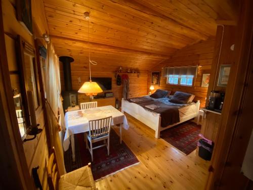a bedroom with a bed and a table in a room at Timrad stuga i kanten av skogen med SPA möjlighet in Mullsjö