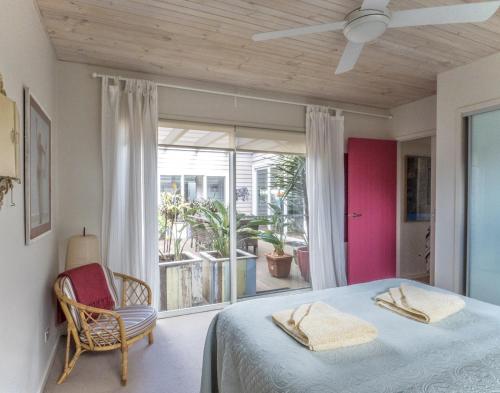 a bedroom with a bed and a large window at 'South Pacific' - Luxury Oceanfront at Culburra! in Culburra Beach