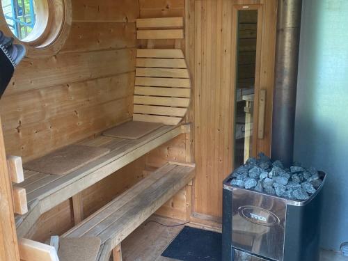 a wooden cabin with a bench and a stove at Timrad stuga i kanten av skogen med SPA möjlighet in Mullsjö
