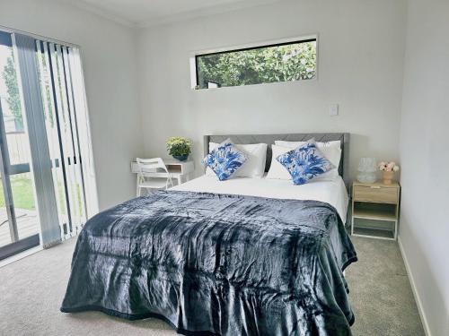 a bedroom with a large bed with blue pillows at Hillcrest Home in Hamilton