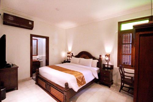 a bedroom with a large bed and a television at Grand Rohan Jogja in Yogyakarta