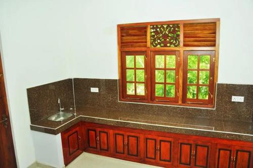 a kitchen with a sink and a window at Randu Homestay and Restaurant in Tangalle
