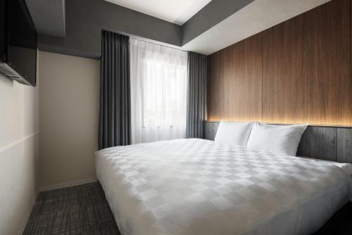 a bedroom with a large bed with a window at the b osaka-shinsekai in Osaka