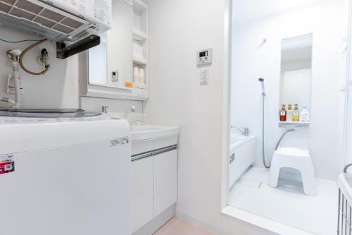 a white bathroom with a sink and a toilet at グランディオーソ沖縄プールヴィラ恩納9 in Onna