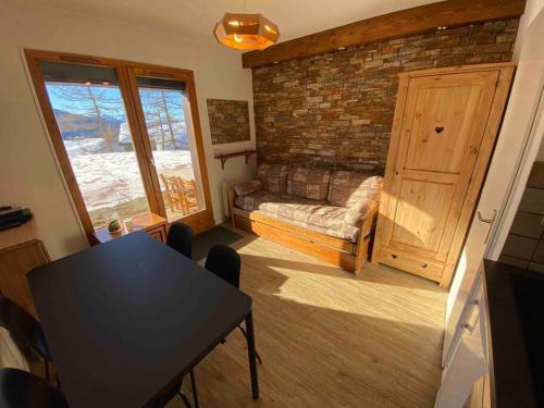- un salon avec une table et un mur en briques dans l'établissement 2 pièces- parking couvert- 4 personnes- les terrasses de la rosiere, à La Rosière