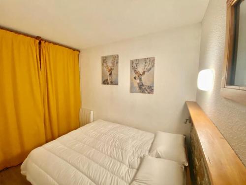 une chambre avec un lit et deux tableaux au mur dans l'établissement 2 pièces- parking couvert- 4 personnes- les terrasses de la rosiere, à La Rosière