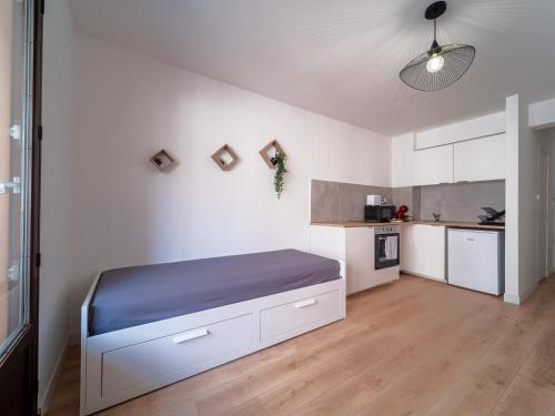 a white room with a bed and a kitchen at Appartement tout équipé à 6 minutes de la Gare St Charles in Marseille