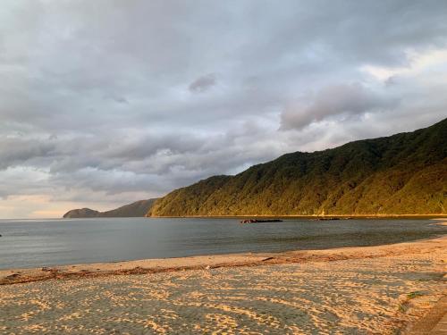 a beach with a boat in the water at Kanzaki Beach House in Kanzaki