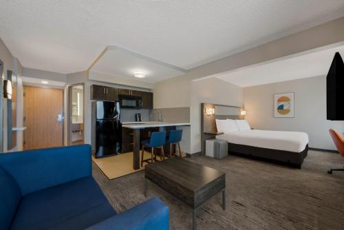 a hotel room with a bed and a living room at Holiday Inn Express Hotels- Hampton by IHG in Hampton