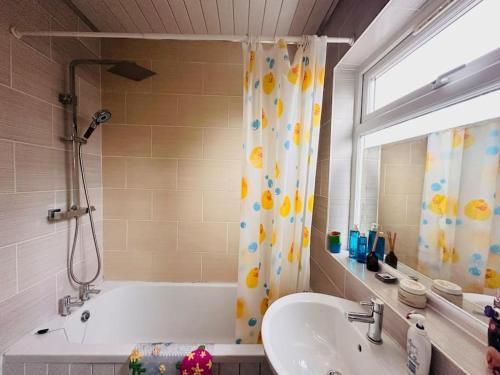 een badkamer met een bad, een wastafel en een douche bij Entire 2 beds terrace house near Ricoh Arena. in Coventry