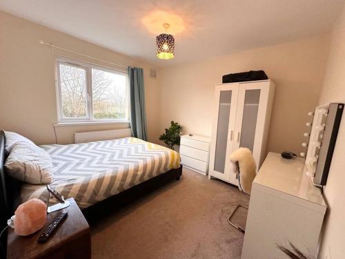 een kleine slaapkamer met een bed en een raam bij Entire 2 beds terrace house near Ricoh Arena. in Coventry