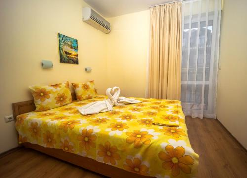 ソゾポルにあるSea Dreams Holiday Homeのベッドルーム1室(黄色い花の掛け布団付きのベッド1台付)