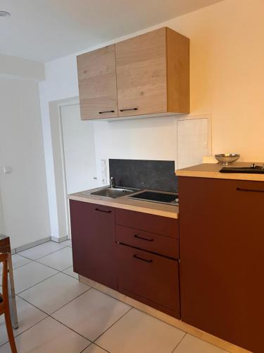 a kitchen with wooden cabinets and a stove top oven at Gasthof Kreuz in Bad Waldsee