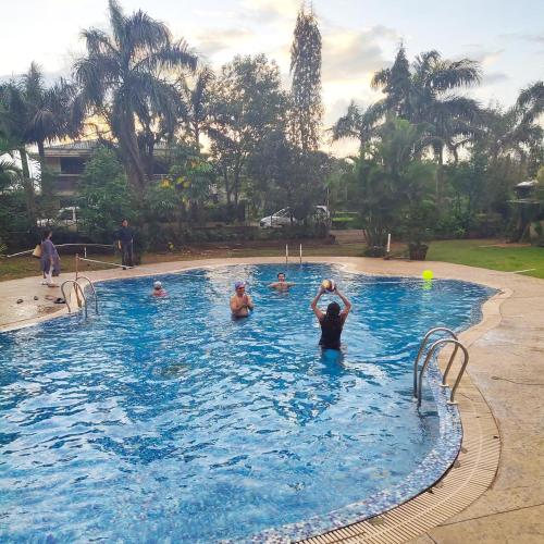 een groep mensen in een zwembad bij Dukes Den Resort in Lonavala