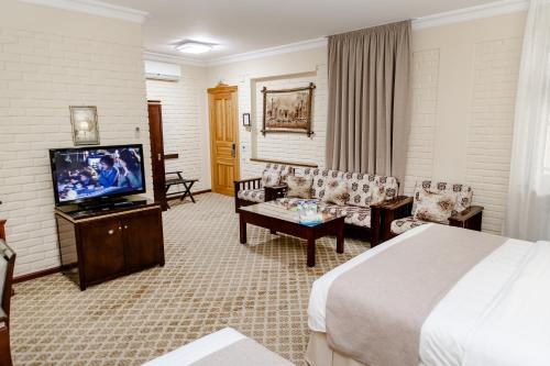 une chambre d'hôtel avec un lit et une télévision à écran plat dans l'établissement Hotel Grand Samarkand Superior - A, à Samarcande