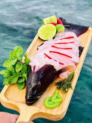 a fish on a cutting board on the water at Nhà Nghỉ Phong Quỳnh - Đảo Phú Quý in Cu Lao Thu