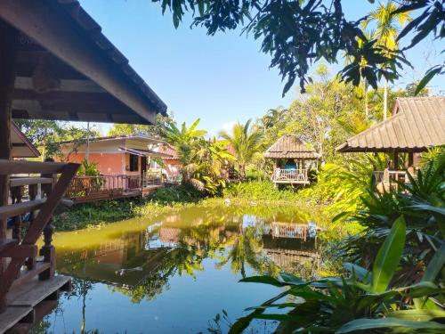 Una vista de un estanque en un complejo turístico. en ต้นพร้าวรีสอร์ท Ton prao Resort, en Ban Pa Tan