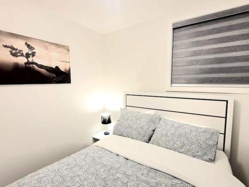 a bedroom with a bed and a picture on the wall at Somy Suite - Cozy 2bedrom with two queens bed and free street parking in Calgary