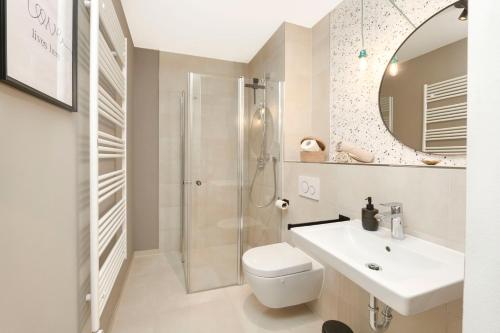 La salle de bains est pourvue d'une douche, de toilettes et d'un lavabo. dans l'établissement Blue Chili 33 - Modernes & gemütliches Business Apartment am Airport BER, à Schönefeld