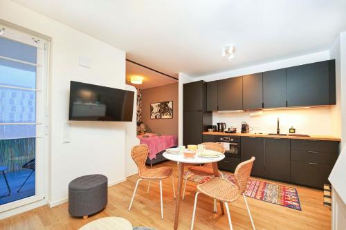 una cucina e un soggiorno con tavolo e sedie di Blue Chili 33 - Modernes & gemütliches Business Apartment am Airport BER a Schönefeld