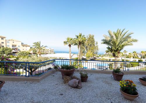 a balcony with potted plants and a view of the ocean at 105 Kings Palace - Fabulous 2 Bed, 2 bath, Large Patio with Garden - Sea Views in Paphos City