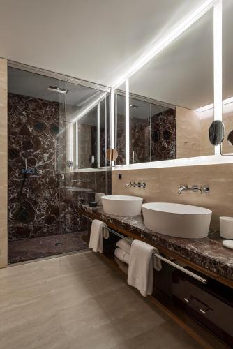 a bathroom with three sinks and a large mirror at Fendi Private Suites - Small Luxury Hotels of the World in Rome